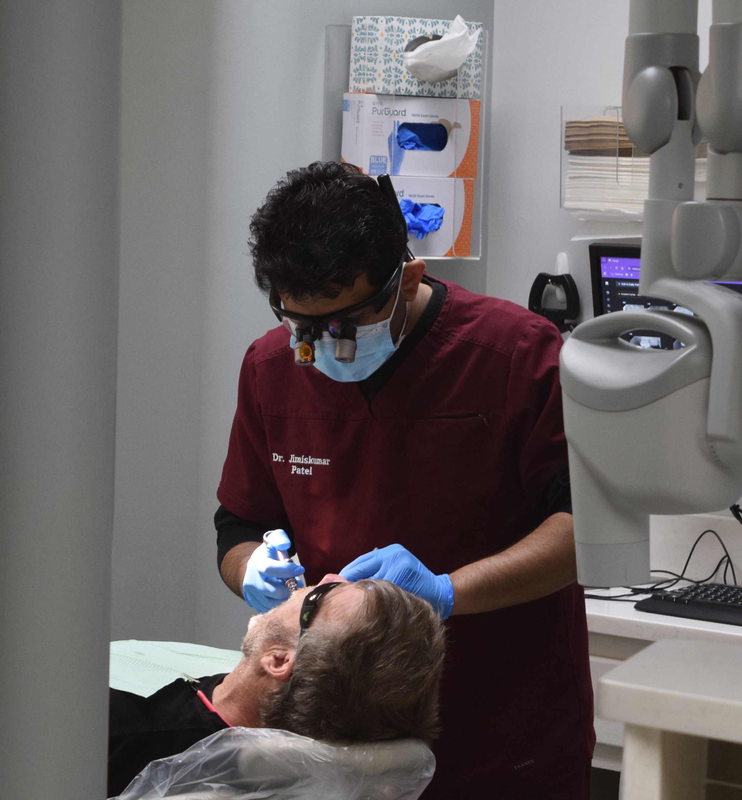 Dr. Jimiskumar Patel providing dental care in the Graham office